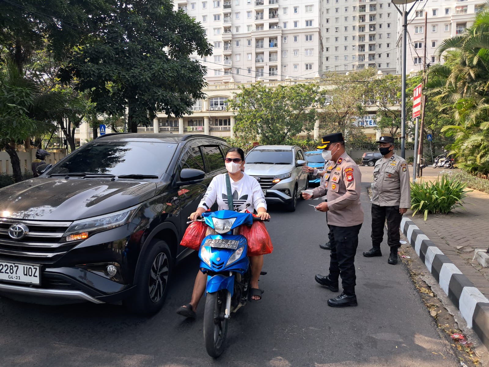 Peduli Warga di Tengah Dampak Erupsi, Kapolsek Kemayoran Bagikan Masker Gratis kepada Pengguna Jalan